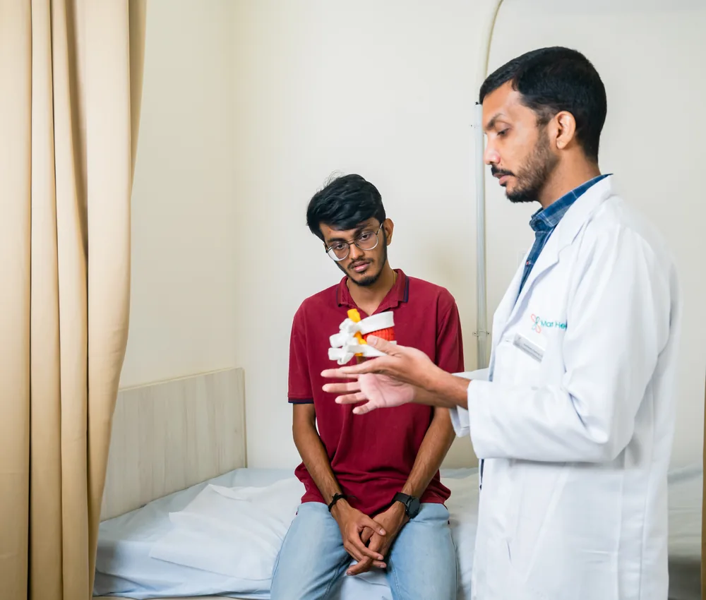 A doctor holding a spine model during a consultation
