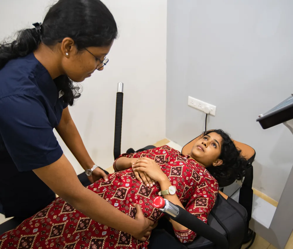 A patient on a spinal decompression system with a physiotherapist beside them