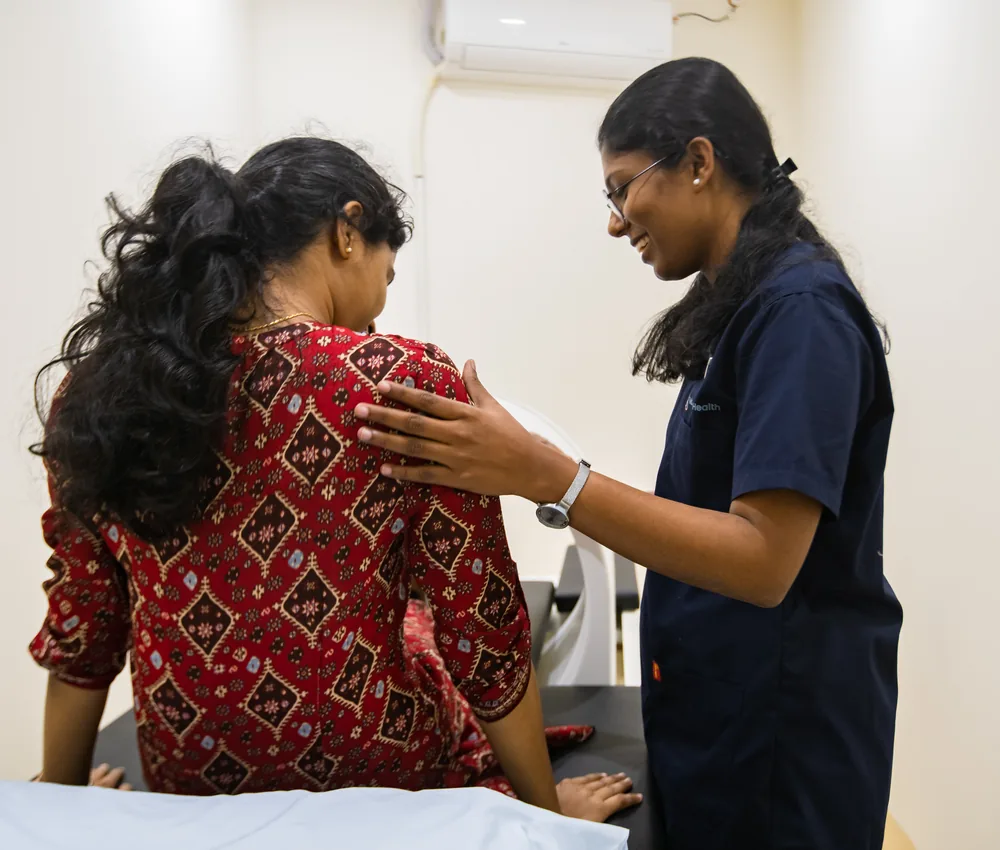 A patient on a spinal decompression system with a physiotherapist beside them