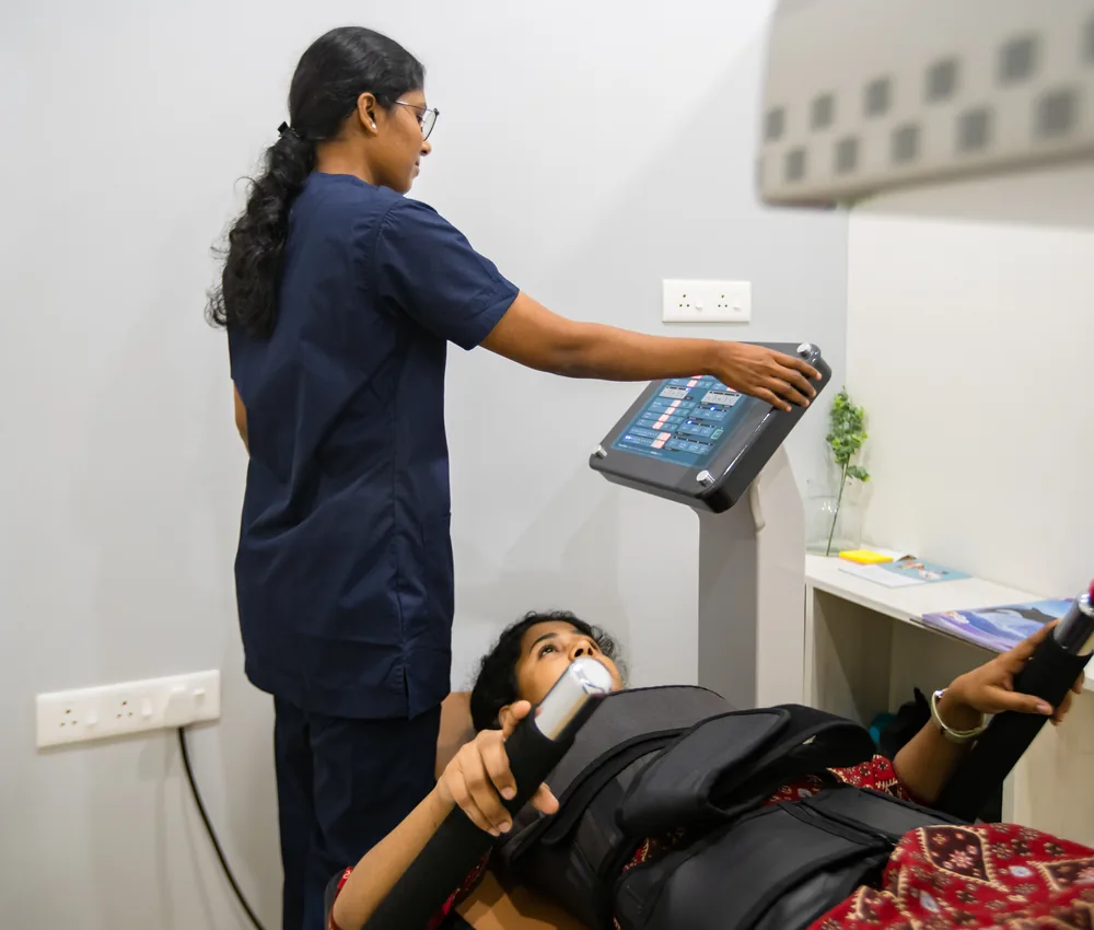 A patient on a spinal decompression system with a physiotherapist beside them