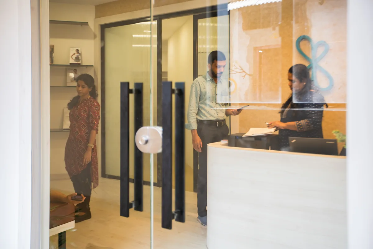 A visitor at the front desk inside a Maana Spine clinic