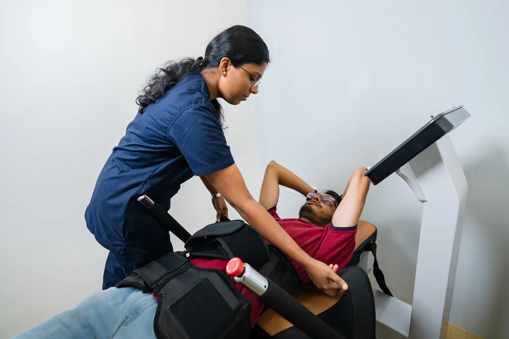 A physiotherapist positioning a patient on the spinal decompression system